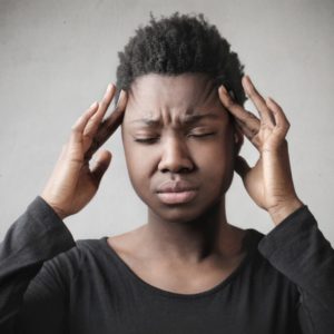 Image of a woman suffering from a headache looking for headache treatment